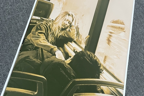 Nuotraukoje du žmonės autobuse ar traukinyje