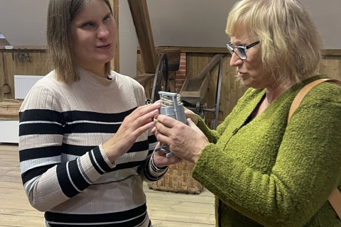 Dvi moterys apžiūri stačiakampį eksponatą